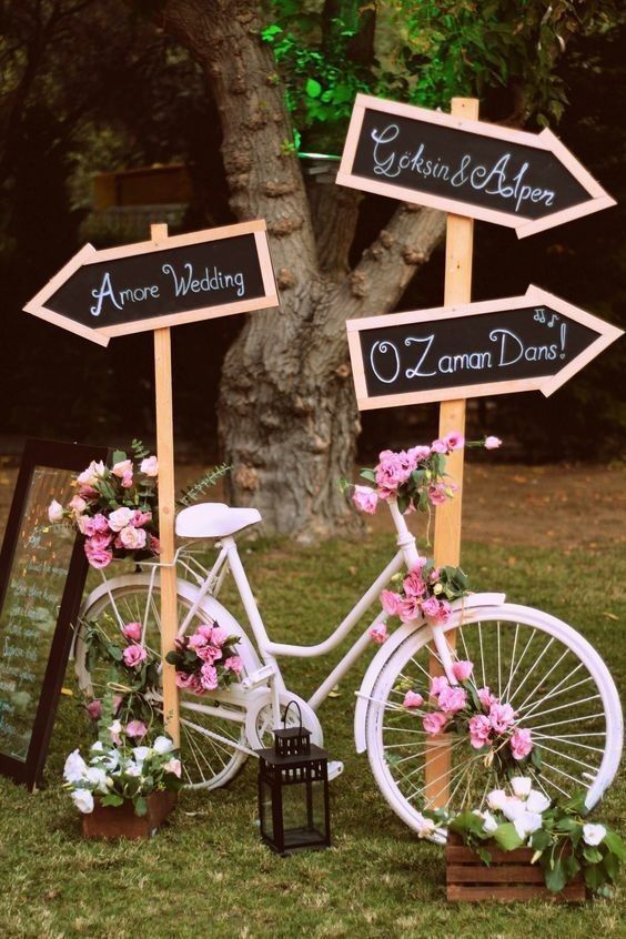 Bike with a signpost covered in pink flowers
